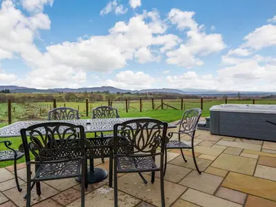 a patio with chairs and a table with a view at Iora Rua-Uk40006 in Gartmore