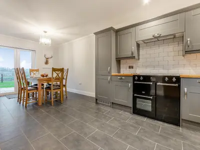 a kitchen with a table and a dining room at Iora Rua-Uk40006 in Gartmore