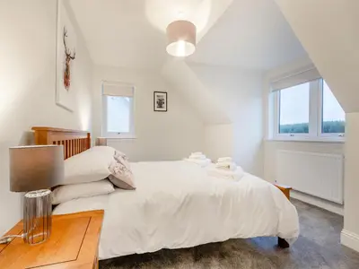 a white bedroom with a large bed and a desk at Iora Rua-Uk40006 in Gartmore
