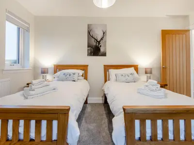two twin beds in a bedroom with white sheets at Iora Rua-Uk40006 in Gartmore
