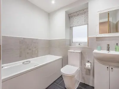 a bathroom with a tub and a toilet and a sink at Fiadh Ruadh-Uk40008 in Gartmore