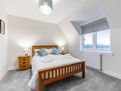 a bedroom with a large bed and a window at Gartclach-Uk40001 in Gartmore