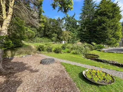 a garden with a tire in the grass at Holly - Apartment in Aberfoyle