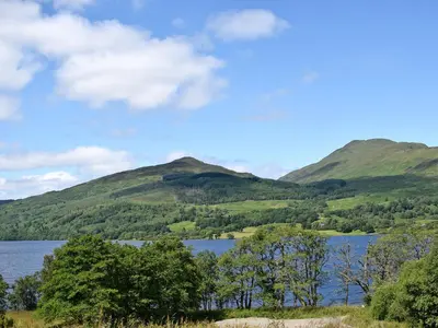 a view of a lake with mountains in the background at Holly - Apartment in Aberfoyle