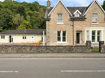 a house on the side of a street at Holly - Apartment in Aberfoyle
