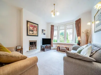 a living room with two couches and a tv at Charles House in Largs