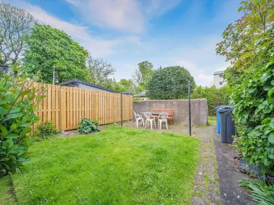 a backyard with a table and chairs and a fence at Charles House in Largs