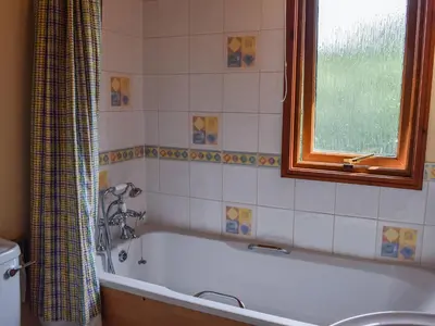 a bathroom with a bath tub and a window at Teasel Lodge - Uk39647 in Lunga