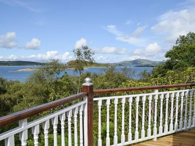 a wooden deck with a view of a body of water at Teasel Lodge - Uk39647 in Lunga