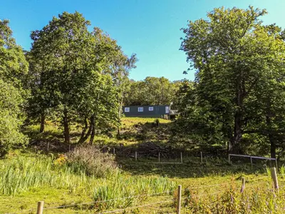 a field with trees and a house in the background at Siskin Lodge - Uk39664 in Lunga