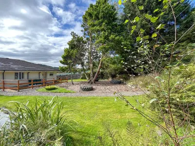 a yard with a house and a tree at Hazel - Apartment in Aberfoyle