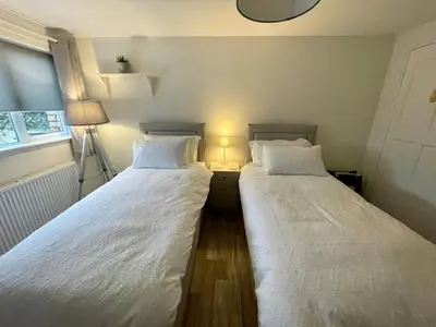 two beds sitting next to each other in a bedroom at Traditional Cottage in West Kilbride Village in Seamill