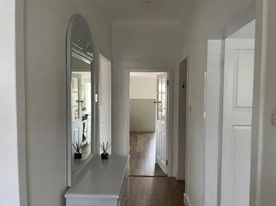 a white room with a mirror and a hallway at Traditional Cottage in West Kilbride Village in Seamill