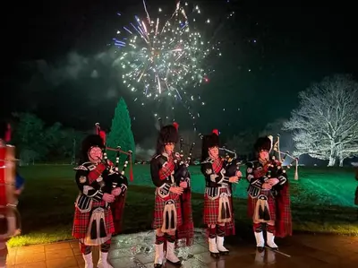 a group of children in kilts playing music with fireworks at Fabulous Lodges at Cameron House, Loch Lomond in Balloch