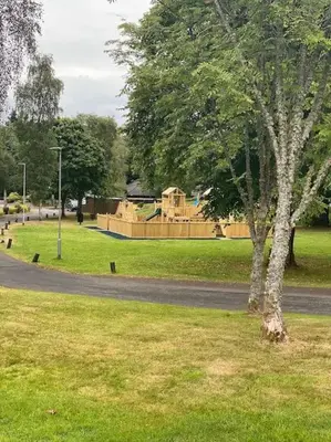 a tree in a park with a playground in the background at Fabulous Lodges at Cameron House, Loch Lomond in Balloch