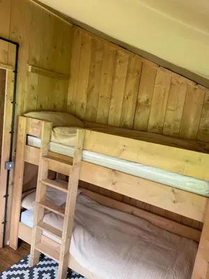 a bunk bed with a ladder in a cabin at Ecosse Glamping in Crossford