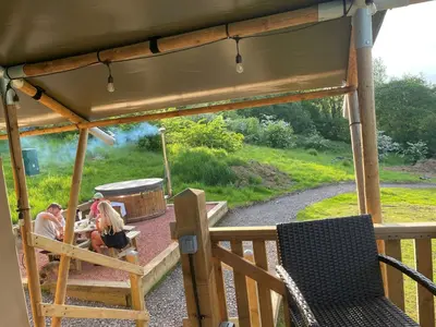a group of people sitting at a table on a deck at Ecosse Glamping in Crossford