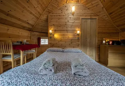 a bedroom with a bed in a wooden cabin at Leven View Lodges - Callart in Fort William