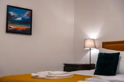 a hotel room with a bed with a painting on the wall at Balvenie Apartment in Oban