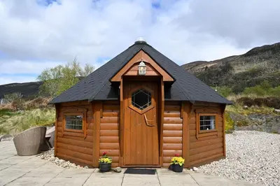 a small wooden cabin with a black roof at Leven View Lodges - Carness in Fort William