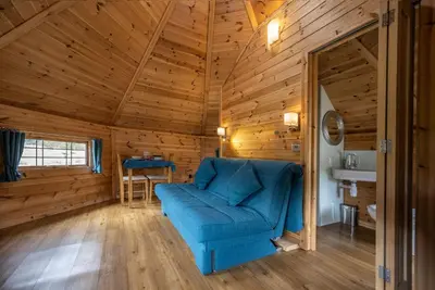 a living room with a blue couch in a wooden room at Leven View Lodges - Carness in Fort William