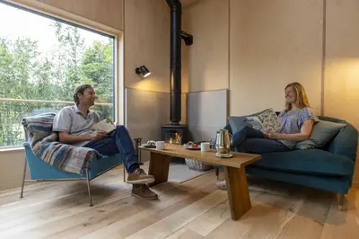 a man and woman sitting on couches in a living room at Mertrick in Forest Mill