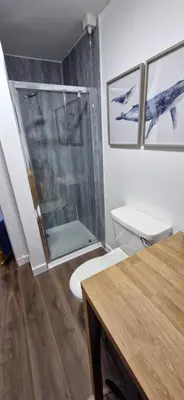 a bathroom with a toilet and a glass shower at Seaview cosy 2 bed home in Lamlash - 'Mid Drive' in Lamlash