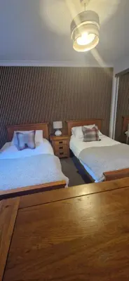 a hotel room with two beds and a light at Seaview cosy 2 bed home in Lamlash - 'Mid Drive' in Lamlash