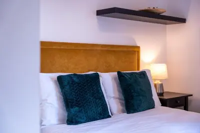 a bed with two green pillows on top of it at Springbank Apartment in Oban