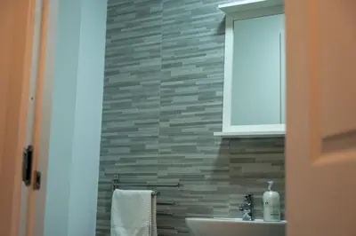 a bathroom with a sink and a brick wall at Springbank Apartment in Oban