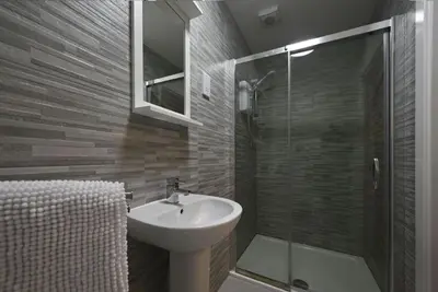 a bathroom with a sink and a glass shower at Talisker Apartrment in Oban