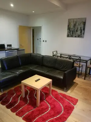 a living room with a black leather couch and a coffee table at Modern 2BD2Bath Apart CityCentre in Glasgow