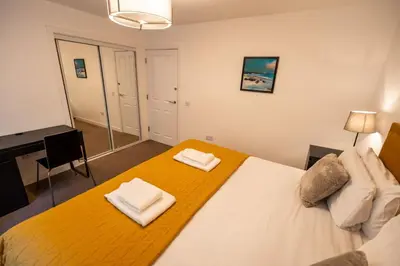 a bedroom with a large bed with two towels on it at Lagavulin Apartment in Oban