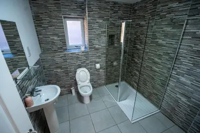 a bathroom with a toilet and a shower and a sink at Ledaig Apartment in Oban