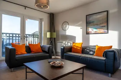 a living room with two couches and a coffee table at Ledaig Apartment in Oban
