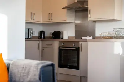 a kitchen with white cabinets and an oven at Ledaig Apartment in Oban