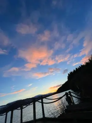 a sunset over a body of water with a fence at Bell Rock Holiday Lodge in Killin