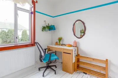 a desk in a room with a chair and a mirror at Bright & Spacious Double Room with Garden View- Close to Airport & City Centre in Edinburgh