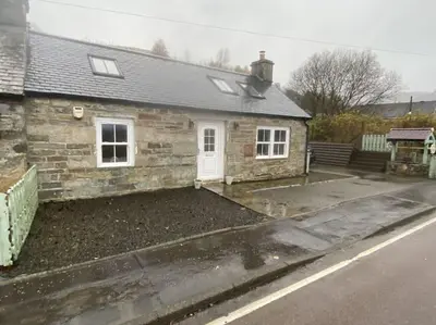 a stone house with a driveway in front of it at The Old Schoolhouse Lochearnhead in Lochearnhead