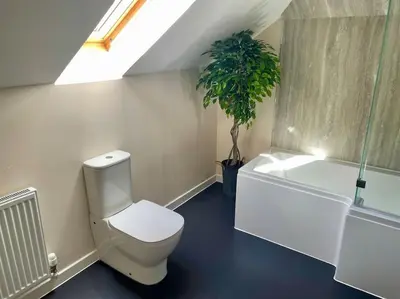 a bathroom with a toilet and a potted plant at Vennel Street Apartments in Stewarton