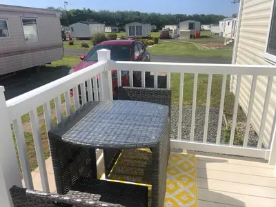 a table on a porch with a white railing at Turnberry Holiday Home in Turnberry