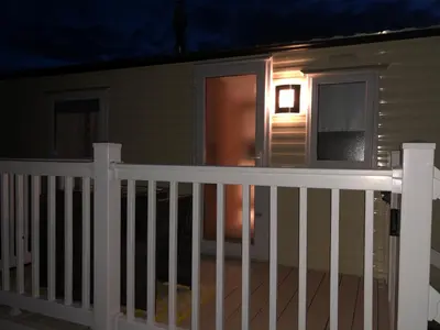 a house with a white railing on a porch at night at Turnberry Holiday Home in Turnberry