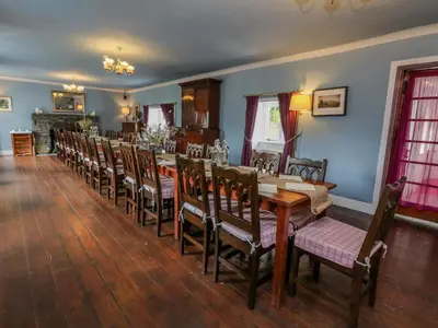 a dining room with a long table and chairs at The House at Bridge of Lochay in Killin