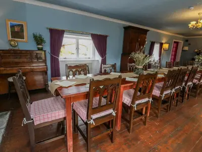 a dining room with a wooden table and chairs at The House at Bridge of Lochay in Killin