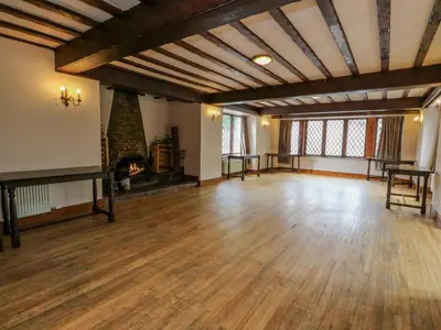 a large room with a wooden floor and a fireplace at The House at Bridge of Lochay in Killin
