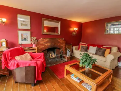 a living room with a couch and a fireplace at The House at Bridge of Lochay in Killin