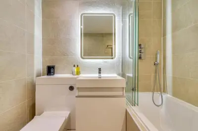 a bathroom with a sink and a shower and a mirror at Lovely 2 Bedroom Garden Flat in trendy West End in Glasgow