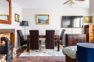 a dining room with a table and chairs and a wood stove at Lovely 1-bedroom property with balcony in West end in Glasgow