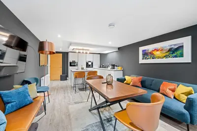a living room with a blue couch and a table at RÌGH Properties - Luxury West End Artisan Apartment in Edinburgh