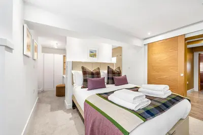 a bedroom with a large bed with purple pillows at RÌGH Properties - Luxury West End Artisan Apartment in Edinburgh